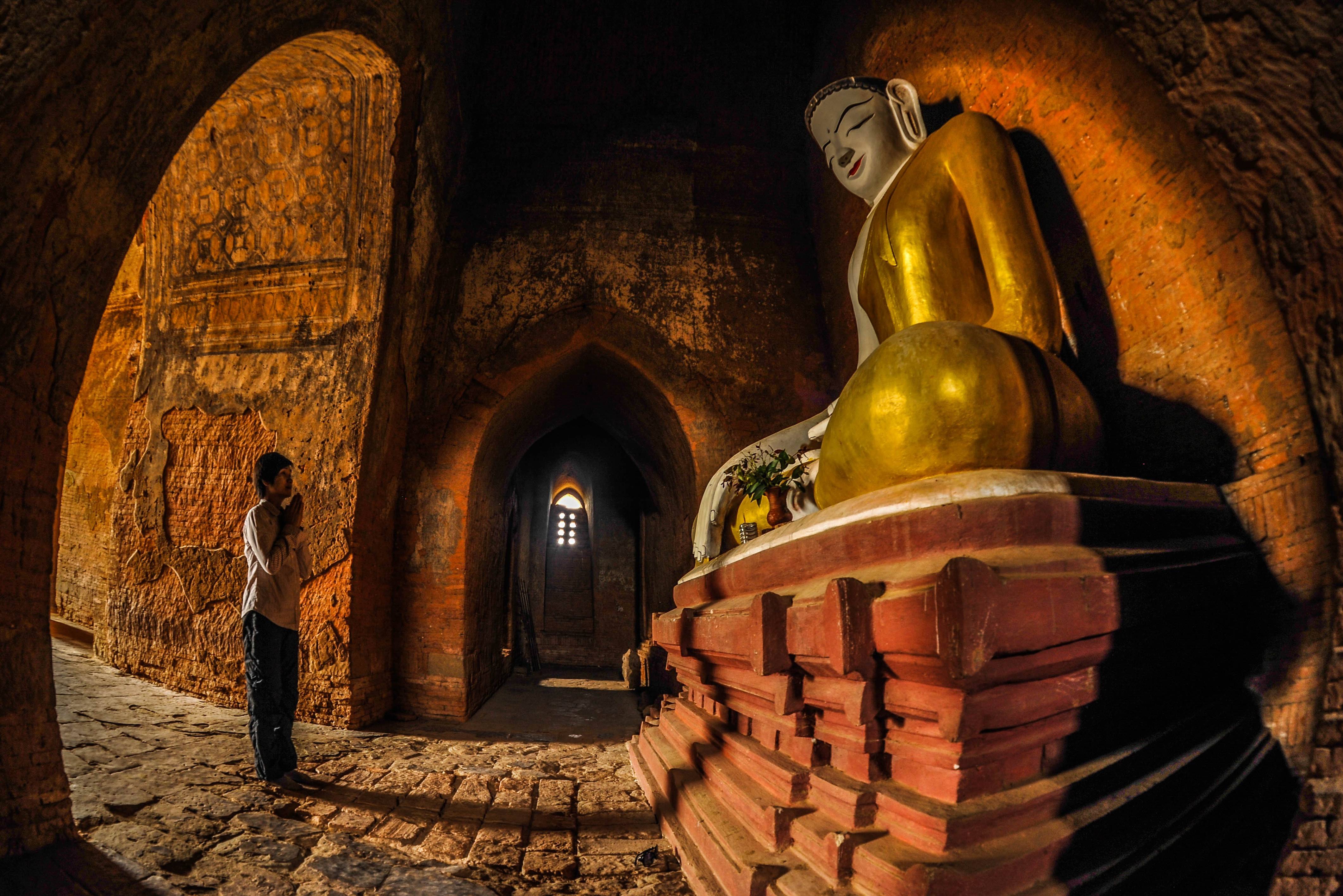 Man bij boeddhabeeld in Bagan Myanmar Birma