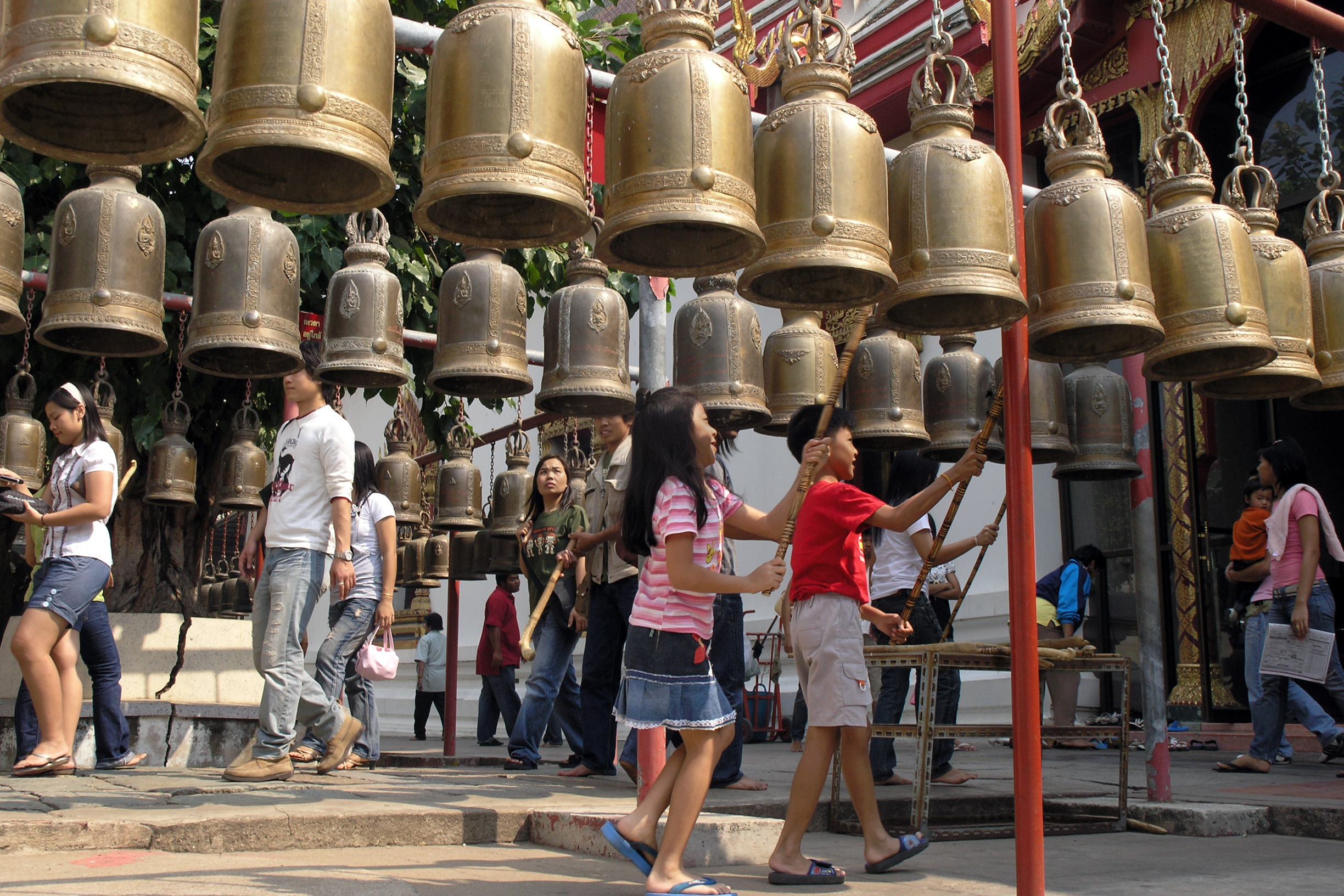 Kinderen luiden boeddhistische bellen bij een tempel in Thailand
